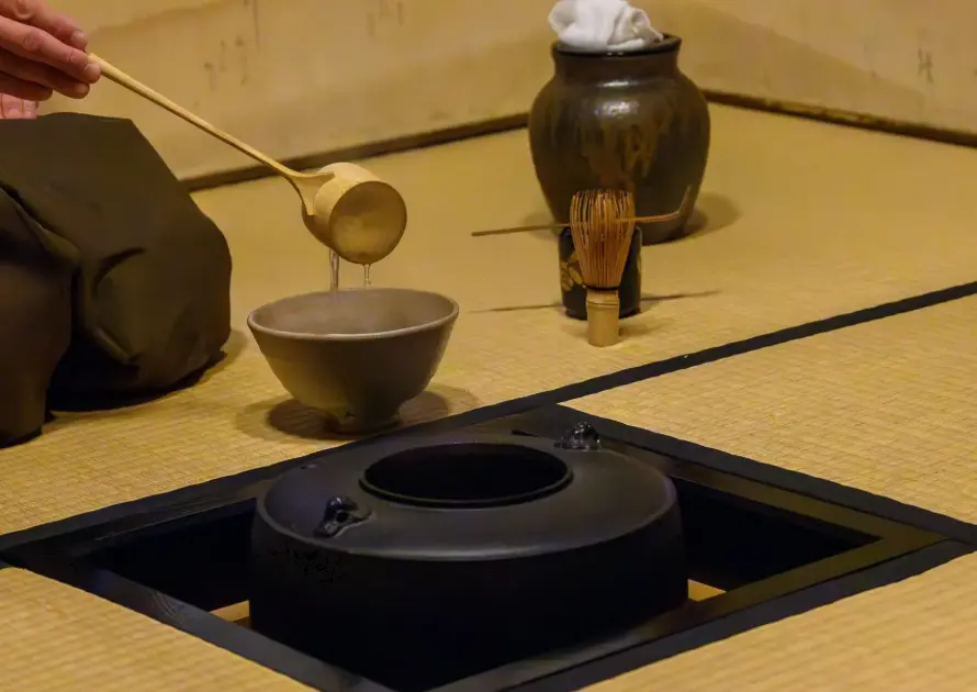 "A person preparing matcha tea during a traditional Japanese tea ceremony."
