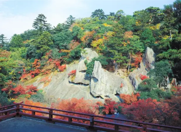 Scenic Buddhist temple with lush gardens and dramatic cliffs.