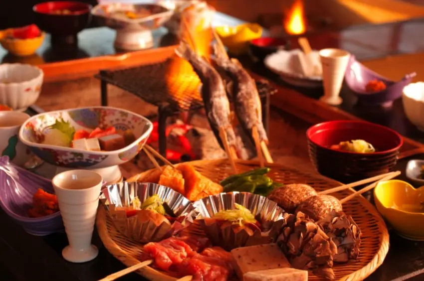 A traditional Japanese irori-style meal in the Hakusan area, featuring grilled fish, local vegetables, and mountain delicacies served by the hearth.