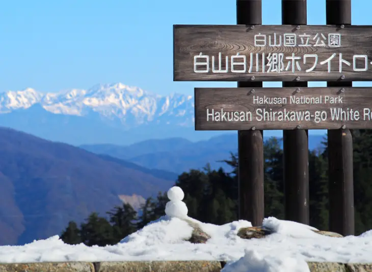 Sign of Hakusan Shirakawa-go White Road in Hakusan National Park, Japan, with snow-covered mountains in the background, representing access to Japan’s sacred mountain by private tours and transfers.