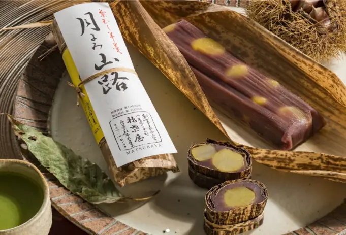 Traditional Japanese confectionery from Kanazawa wrapped in bamboo leaves, featuring sweet red bean and chestnut flavor.