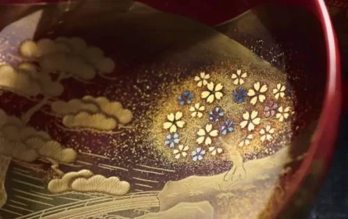Close-up of traditional Kanazawa lacquerware decorated with gold and colorful maki-e patterns.