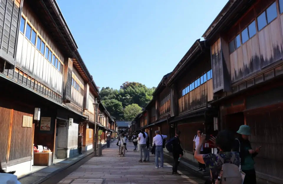 Private tour guests exploring the historic Higashi Chaya District with a local guide in Kanazawa.