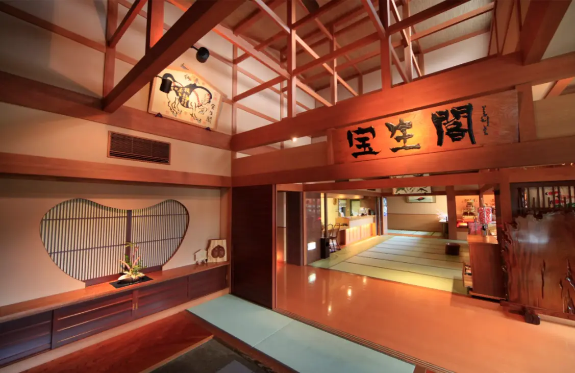 Warmly lit wooden entrance and lobby interior of a traditional ryokan in Takayama