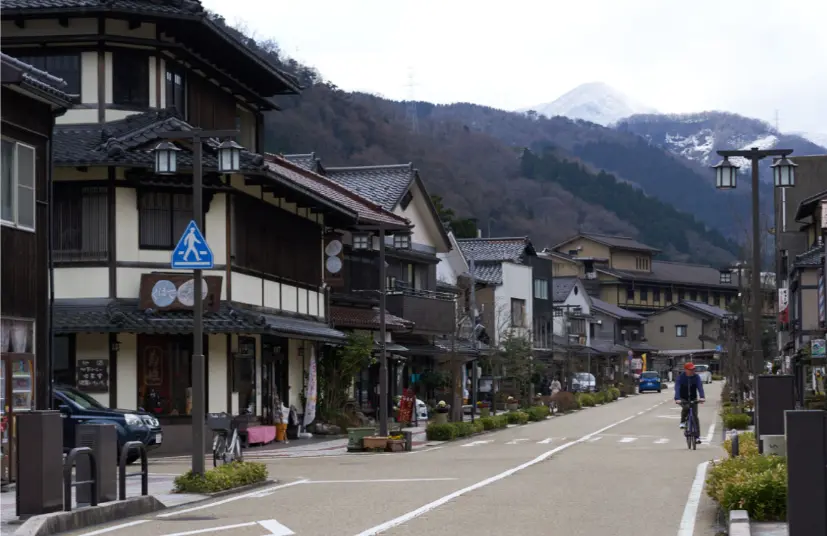 Traveler arriving at Kaga Onsen town surrounded by mountains and traditional inns