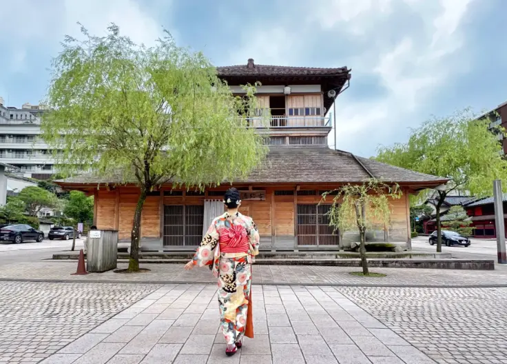 Visitors walking quietly through Yamashiro Onsen in yukata robes at sunset