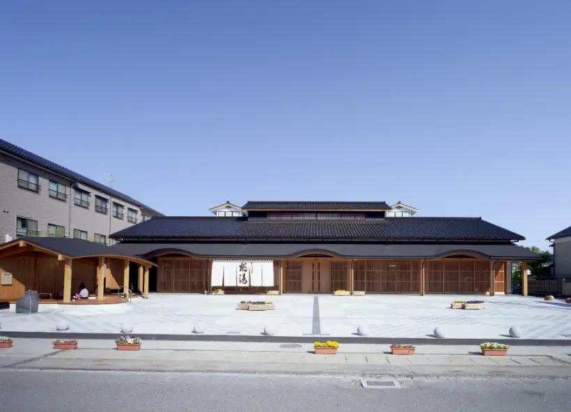 Traditional wooden hot spring facility in Wakura Onsen under clear blue sky