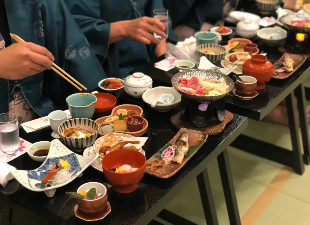 Guests wearing yukata enjoying a traditional kaiseki dinner at a ryokan in Noto