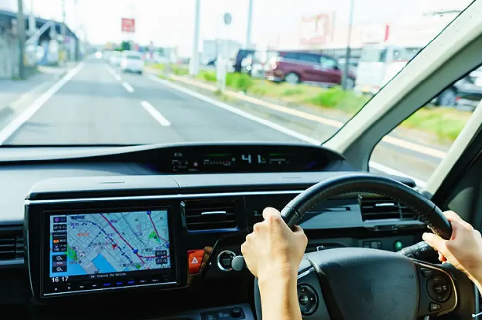 Driver navigating through a Japanese road with GPS navigation inside a car