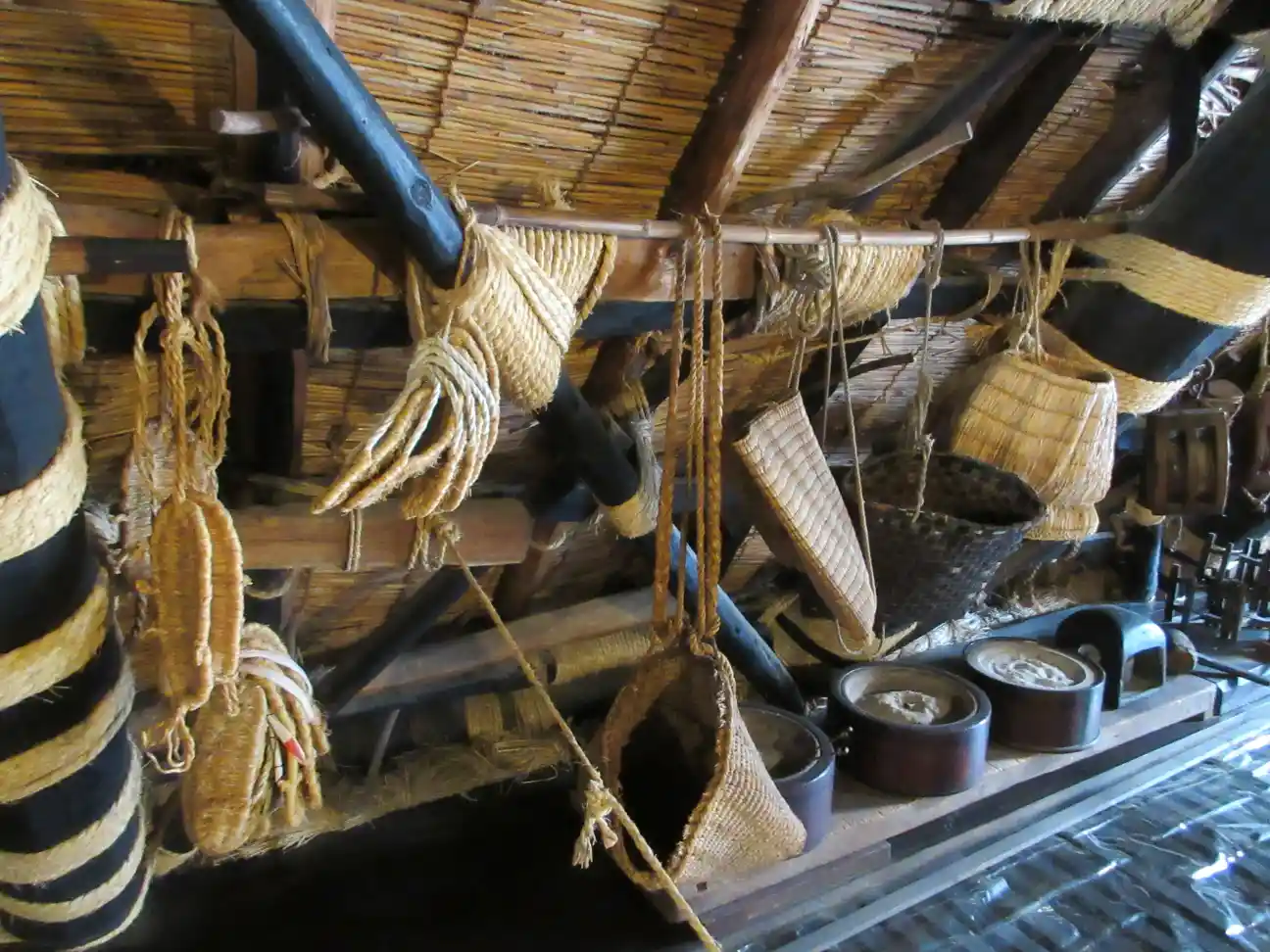 The attic interior of Wada House in Shirakawa-go featuring traditional farming tools, woven baskets, and ropework used in village life.