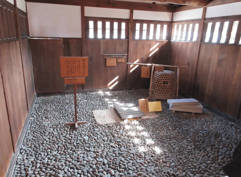 Interior view of the Oshirasu interrogation and judgment area at Takayama Jinya, featuring a stone-covered floor and Edo-period décor.