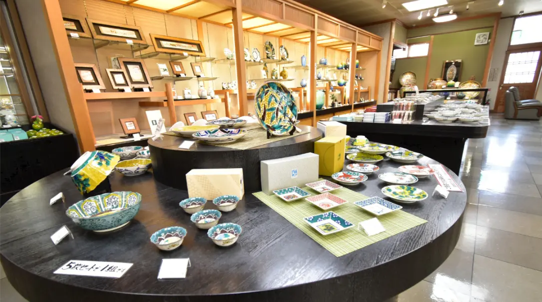 A display of colorful Kutani ware plates and bowls inside the Kutani Mangetsu shop in Kaga, Ishikawa.