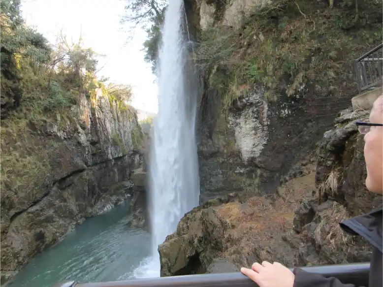 A powerful waterfall cascading into a turquoise pool in a narrow gorge in the Hakusan area of Japan.