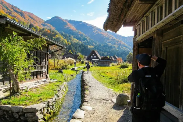 A narrow path and waterway running through a traditional rural village.
