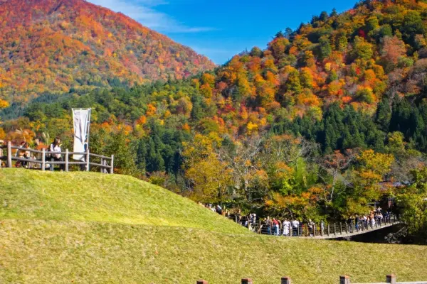 Deai-bashi suspension bridge entrance to Shirakawa-go with autumn foliage.