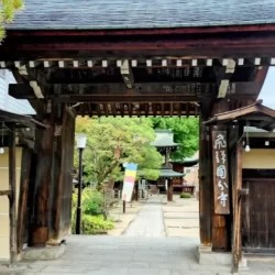 Main gate of Hida Kokubunji Temple in Takayama, leading to the temple grounds with traditional wooden structures.
